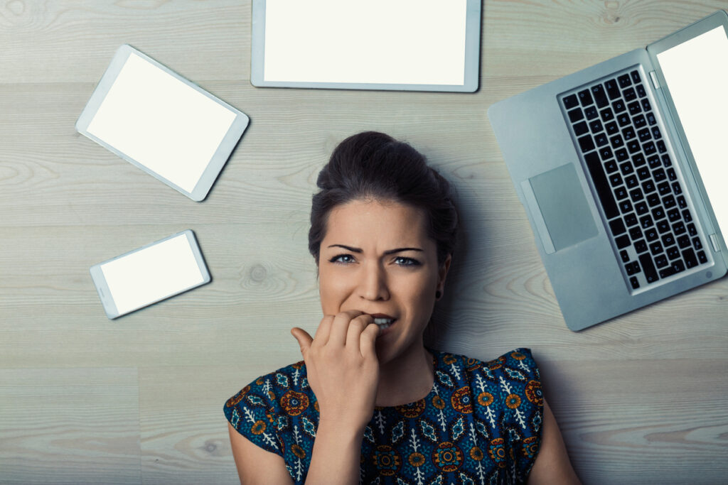 persona che si mangia le unghie dalla paura di fianco a un pc