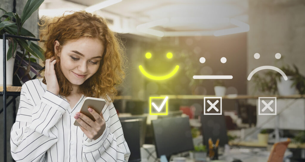 ragazza con capelli rossi guarda il telefono con il sorriso